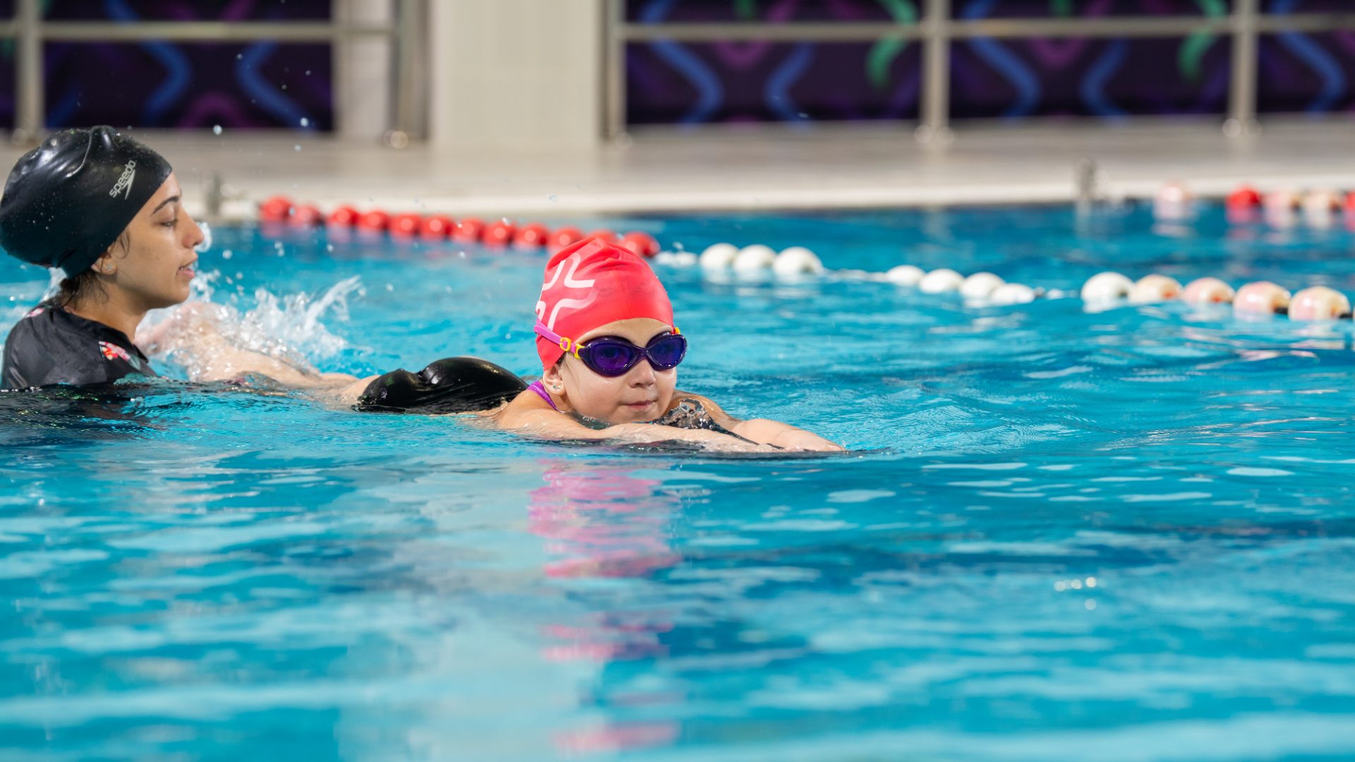 Coach teaching a child to swim