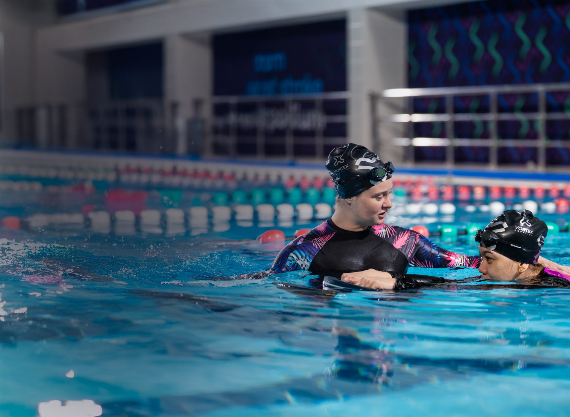 Coach guiding a lady swimmer